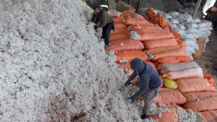 ARCHIV, 13.1.2020: Arbeiter befüllen Säcke mit Baumwolle in einer Baumwollfabrik in der Provinz Kandahar im Süden Afghanistan (Bild: picture alliance/dpa/XinHua)