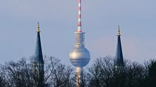 Vom Tempelhofer Feld aus gesehen, steht der Berliner Fernsehturm mittig hinter den Türmen der Sehitlik-Moschee in Neukölln (Bild: dpa / Wolfram Steinberg)