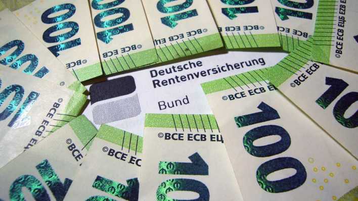 Geldscheine liegen auf einem Rentenbescheid der Deutschen Rentenversicherung (Bild: picture alliance / SvenSimon)