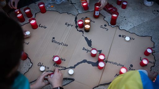 Demonstranten stellen Grablichter als Symbol für im Krieg getöteten Menschen auf eine Karte der Ukraine.