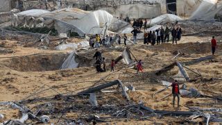 Palästinenser überprüfen die Trümmer von Gebäuden, die durch israelische Luftangriffe beschädigt wurden in Rafah