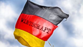 FOTOMONTAGE, Zerschlissene Deutschlandfahne im Wind mit Aufschrift Wirtschaft
