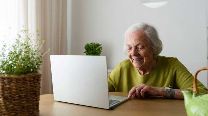 Seniorin an einem Laptop