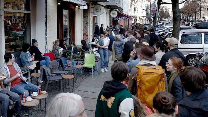 Menschen stehen in einer langen Schlange vor einem Berliner Eisladen