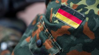 Die Fahne von Deutschland ist auf der Uniform eines Soldaten aufgenäht.