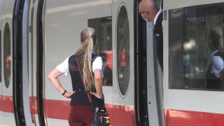 Zugbegleiter der DB Deutsche n Bahn AG stehen ratlos in und an einem verspäteten ICE im Hauptbahnhof Frankfurt