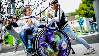 Inklusiver Spielplatz, auf dem Kinder mit und ohne Behinderung spielen