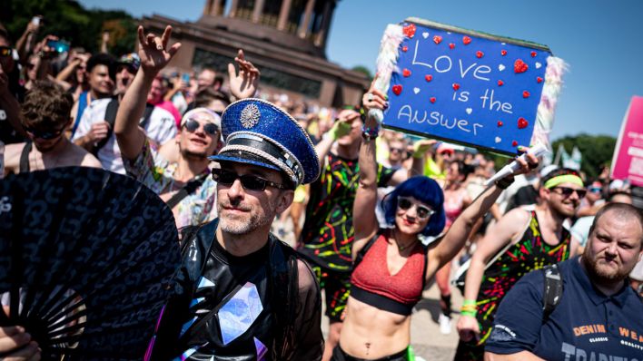 Eine Frau hält beim Rave the Planet ein Schild mit der Aufschrift "Love is the answer" empor. (Quelle: Picture Alliance)