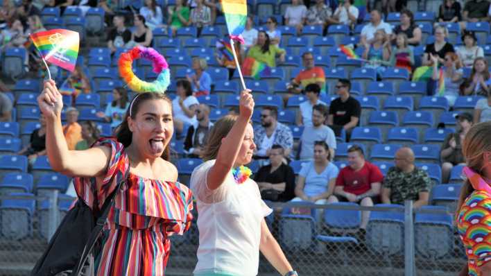 Eine Teilnehmerin der Eröffnungsparade der WorldPride streckt im Stadion von Malmö die Zunge raus. (Bild: picture alliance/dpa)