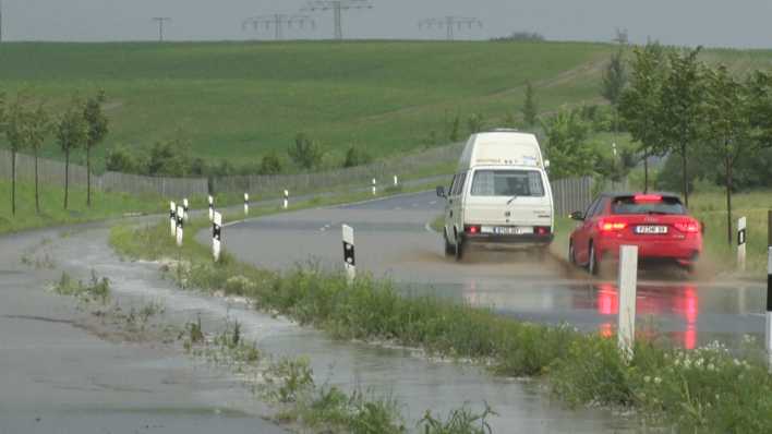 Autos fahren über die L26 zwischen Schenkenberg und Prenzlau, auf der das Wasser steht