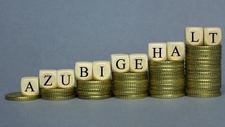 Steigende Geldstapel mit den Buchstaben "Azubigehalt" drauf. (Bild: IMAGO / Steinach)