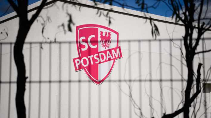 Das Logo des Sportvereins SC Potsdam e.V. in Drewitz ist hinter einem Zaun zu sehen.