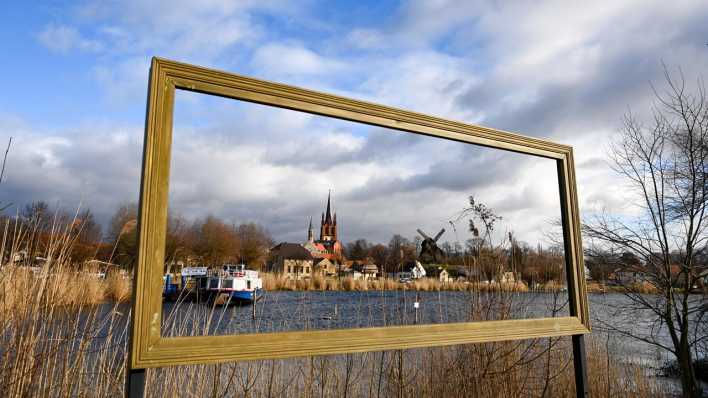 Durch einen Bilderrahmen am Ufer der Havel ist die Stadt Werder zu sehen.
