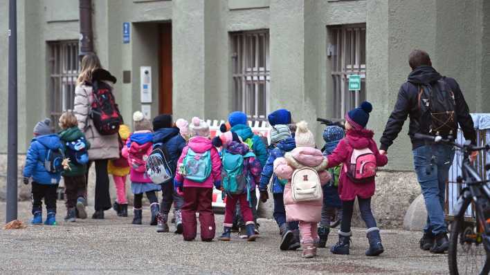 Kindergartenkinder mit Betreuer und Betreuerin machen eine Wanderung.