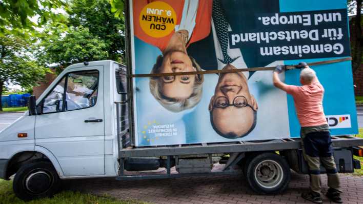 Auf einen Transporter wird ein Wahlplakat der CDU nach dem Abbau verladen.