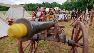 Als Bauern kostümierte Darsteller eines historischen Bauernzuges stehen im Heereslager zur Nachstellung der Bauernschlacht vor 500 Jahren in Bad Frankenhausen (Bild: picture alliance/dpa/Matthias Bein)