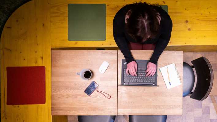 Eine Frau sitzt im Homeoffice am Küchentisch