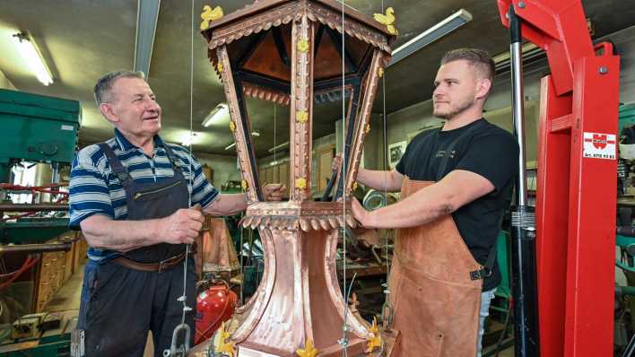 Metallbaumeister Wilfried Schwuchow steht in seiner Werkstatt zusammen mit seinem Sohn Paul, an einem Neubau einer historischen, kupfernen Straßenbeleuchtung