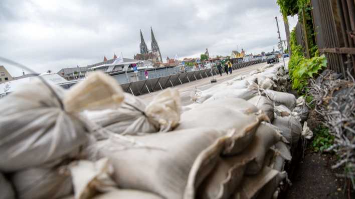 Ein Uferweg in Regensburg ist mit einer mobilen Hochwasser-Schutzwand gesichert, Sandsäcke liegen bereit. (Bild: picture alliance/dpa/Pia Bayer)