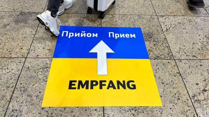 Ein Hinweisschild zeigt die Richtung zur zentralen Anlaufstelle für ankommende Geflüchtete aus der Ukraine am Kölner Hauptbahnhof (Bild: picture alliance/Flashpic/Jens Krick)