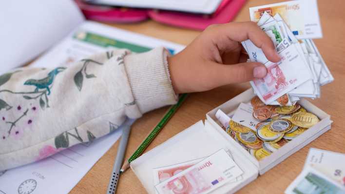 Eine Schülerin einer 2. Klasse rechnet im Klassenzimmer einer Grundschule mit Spielgeld (Bild: picture alliance/dpa/Sven Hoppe)