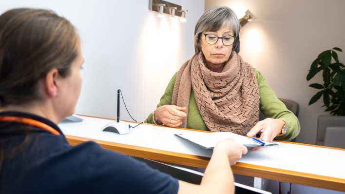 Eine Patientin wird in einer Praxis von einer Sprechstundenhilfe beraten.