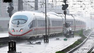 Ein ICE fährt bei Regen in den Kölner Hauptbahnhof.