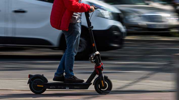 Ein Mann auf einem E-Scooter auf einem Fahrradweg in Berlin