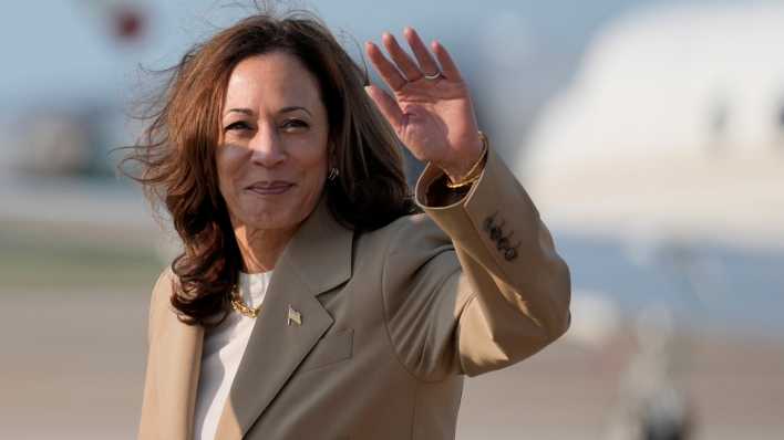 Die US-Vizepräsidentin Kamala Harris winkt nach der Landung mit einem Flugzeug auf einer Militärbasis.