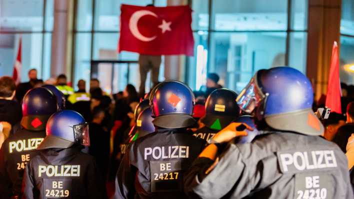 Polizisten geleiten feiernde Türkei-Fans von der Fahrbahn des Kurfürstendamms.