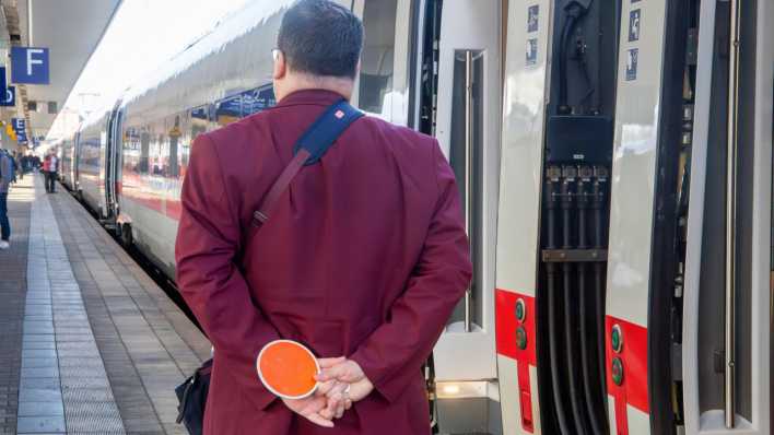 Zugbegleiter am Hauptbahnhof Mannheim vor einem abfahrenden ICE (Bild: picture alliance/CHROMORANGE/Udo Herrmann)