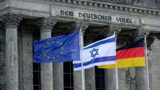 Vor dem Reichsttagsgebäude wehen Fahnen mit der israelische Staatsflagge.