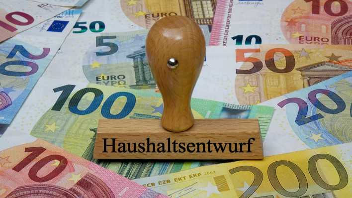 Auf Geldscheinen steht ein Stempel mit dem Schriftzug "Haushaltsentwurf" (Bild. picture alliance / ZB | Sascha Steinach).