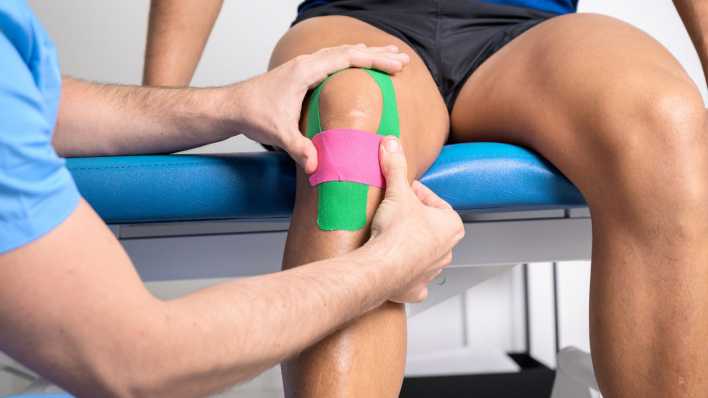 Symbolfoto: Kinesiotape am Knie eines Patienten