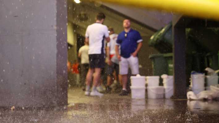 Fußball-Fans bei der EM schützen sich vor dem Regen