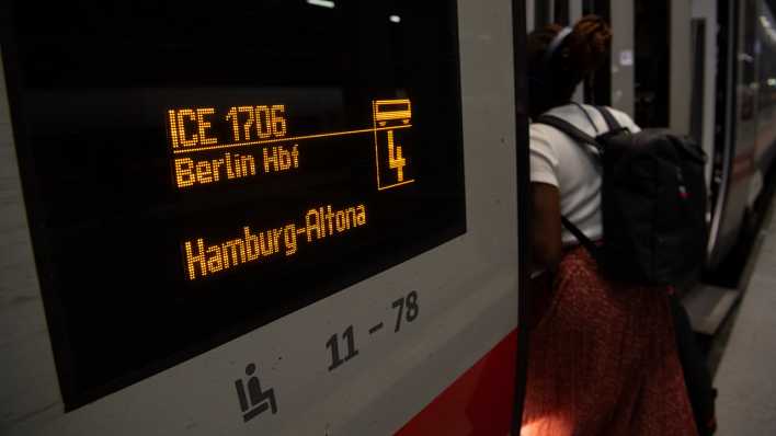 Eine Frau steigt im Hauptbahnhof Berlin in einen Zug nach Hamburg-Altona.