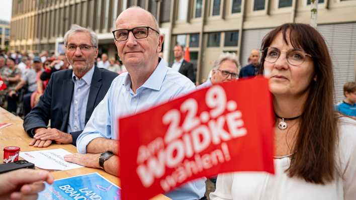 Brandenburgs Ministerpräsident Dietmar Woidke sitzt beim SPD-Sommerabend 2024 in Potsdam zusammen an einem Tisch mit dem früheren Regierungschef Matthias Platzeck und Finanzministerin Katrin Lange.