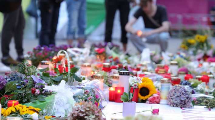 Nach der Messerattacke auf dem Solinger Stadtfest legen Menschen in der Nähe des Tatortes Blumen nieder und und zünden Kerzen zum Gedenken der Opfer an.