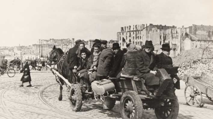 Menschen 1945 in den Ruinen von Warschau.