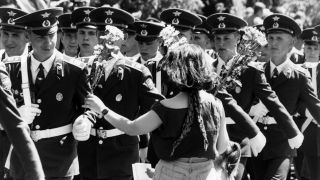 Eine Frau schenkt den vorbeimarschierenden russischen Soldaten Blumen während einer Militärparade der russischen Armee zum Abzug der Truppen aus Berlin am 25.06.1994.