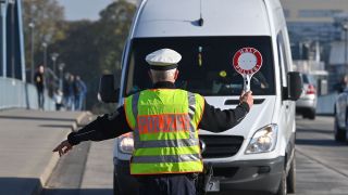 Ein Beamter der Bundespolizei stoppt einen Fahrer eines Kleintransporters bei der Einreise nach Deutschland am deutsch-polnischen Grenzübergang