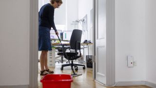 Eine Frau reinigt ein Büro