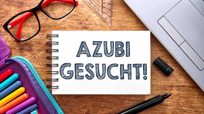 Ein Notizbuch mit der Aufschrift "Azubi gesucht!" symbolisiert die aktive Suche nach Auszubildenden (Bild: picture alliance/CHROMORANGE/Michael Bihlmayer)