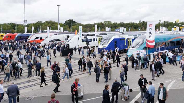 Fachbesucher zwischen ausgestellten Zügen verschiedener Hersteller auf dem Freigelände der Bahntechnikmesse InnoTrans 2024 (Bild: picture alliance/dpa/Carsten Koall)