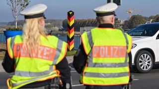 Eine Beamtin und ein Beamter der Bundespolizei stehen am deutsch-polnischen Grenzübergang Stadtbrücke in Frankfurt (Oder) und überwachen den Einreiseverkehr.