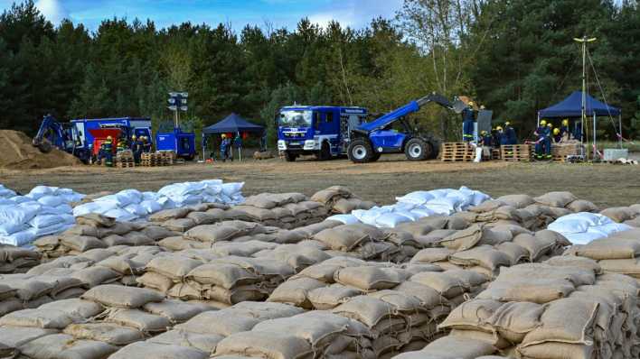 Ehrenamtliche Helfer vom Technischen Hilfswerk füllen Sandsäcke gegen das Hochwasser des Flusses Oder. (Bild: picture alliance/dpa/Patrick Pleul)