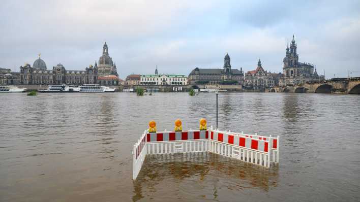 Absperrungen stehen gegenüber der Altstadtkulisse Dresden auf den von der Elbe überfluteten Elbwiesen.