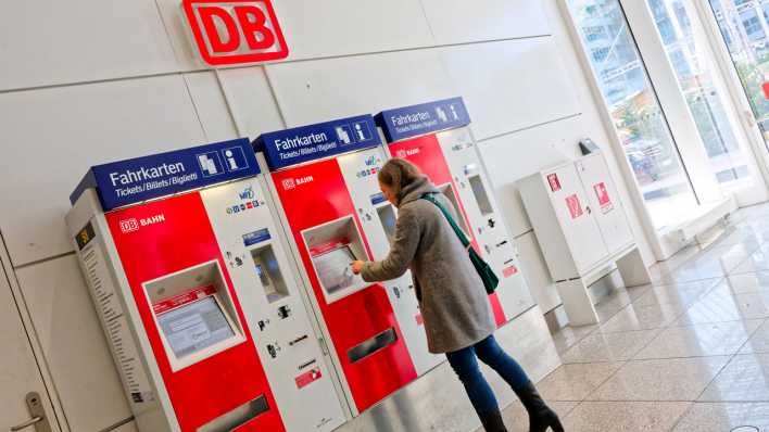 Bahnticketkauf. Die Frau kauft sich die Fahrkarte am Automaten