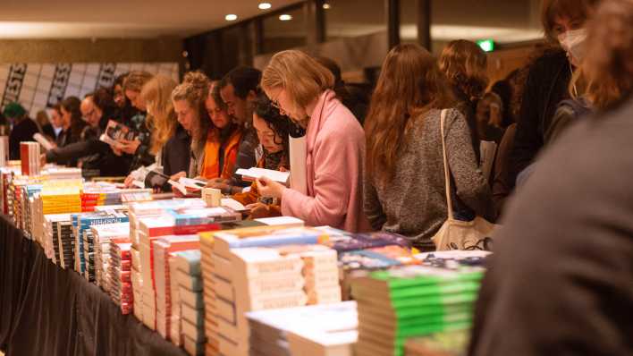 Besucherinnen und Besucher an einem Büchertisch beim Internationalen Literaturfestival Berlin.