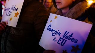 Teilnehmende einer Demonstration in Georgien halten Zettel mit der Aufschrift "Georgia Votes for EU".